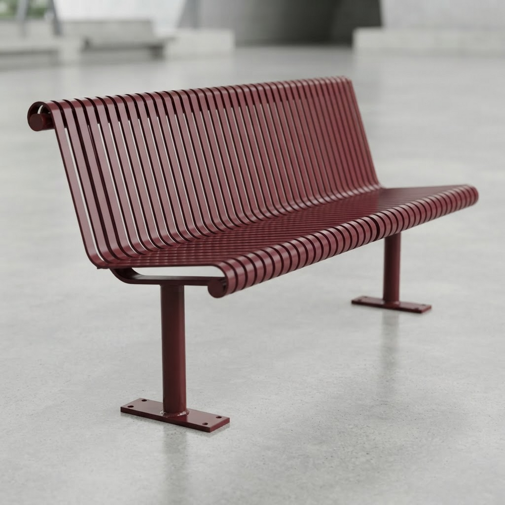 A modern metal bench with a curved, ribbed slatted design in a deep burgundy red, set against a neutral gray concrete floor and blurred background.