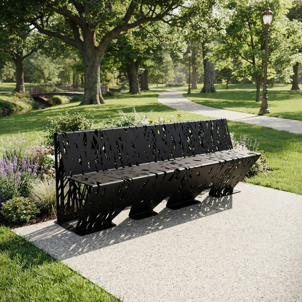 A modern black metal park bench with a decorative cutout pattern, situated on a concrete pathway in a lush green park.