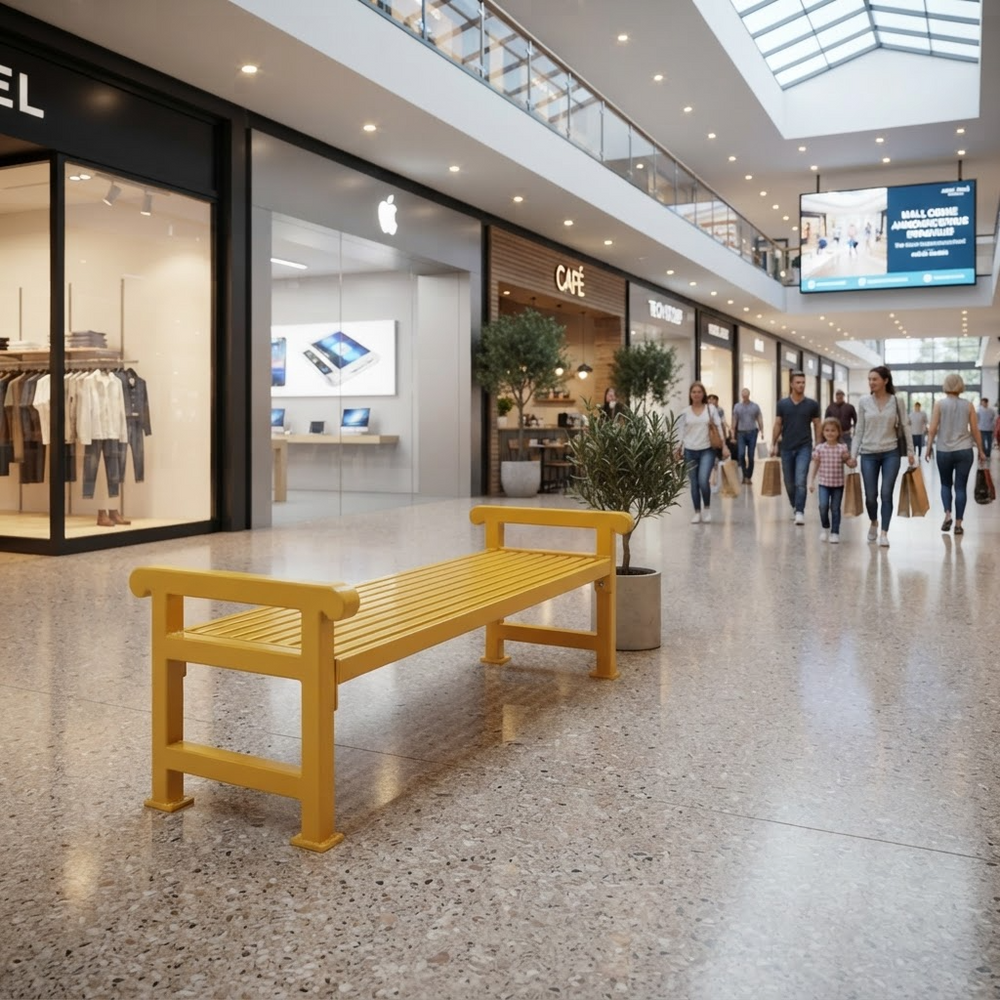 A bright yellow slatted bench placed in a modern shopping mall corridor with visible storefronts, walkways, ceiling lights, and shoppers in the background.