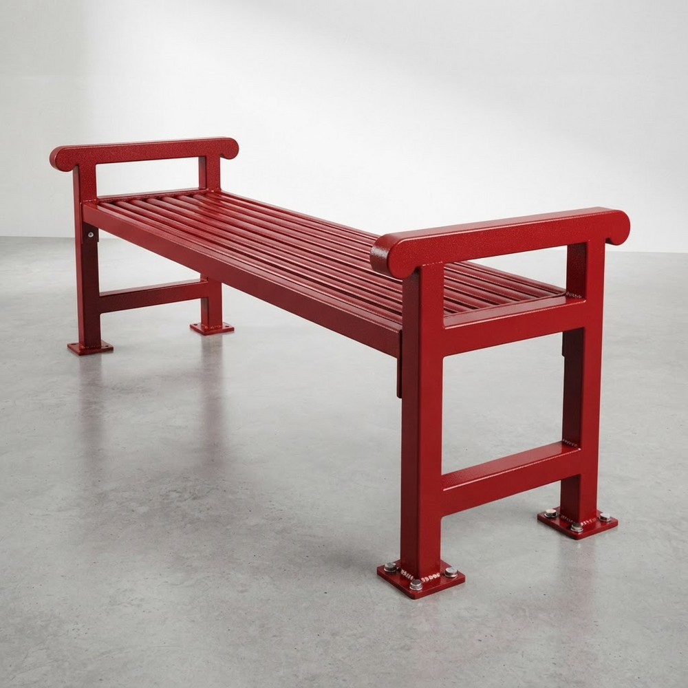 A modern red metal bench with a slatted seat and armrests, photographed in a minimalist studio setting with a gray floor and white wall.