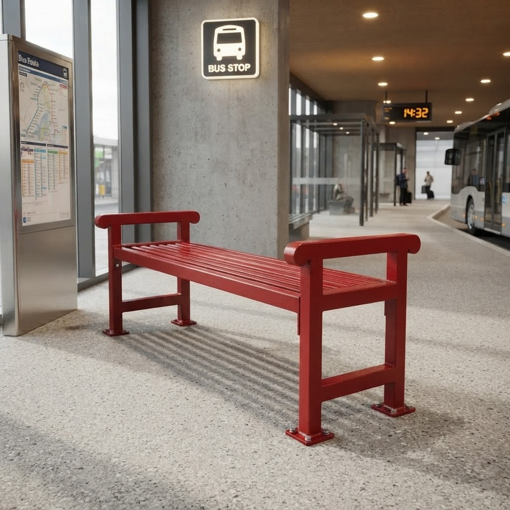 A bright red outdoor bench with armrests and a slatted seat, placed at a bus stop in a modern transit station. A bus stop sign, transit map, concrete pillar, and a bus are visible in the background.