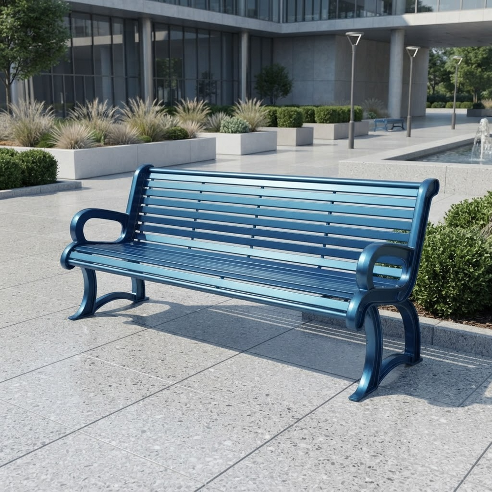 A modern outdoor bench with blue metal slats and armrests, positioned on a paved plaza in front of a contemporary building with greenery.