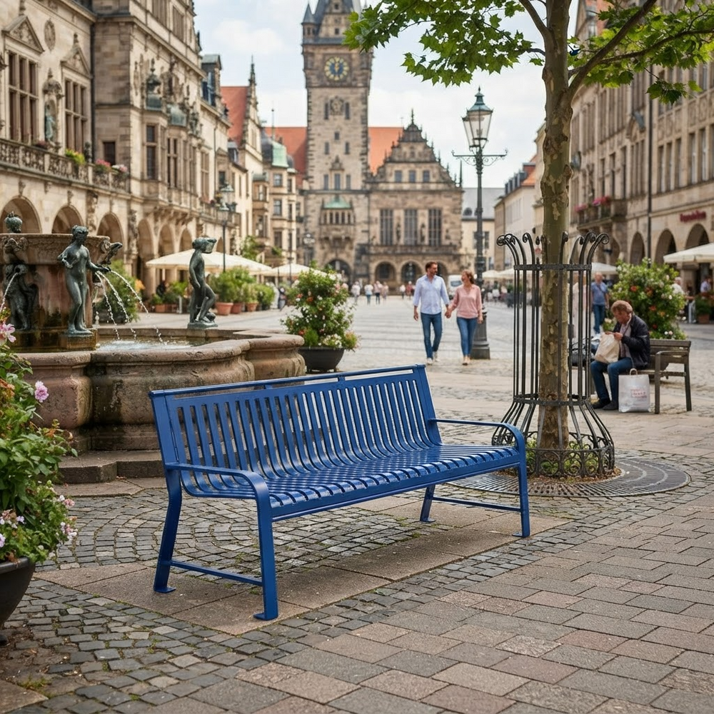 A bright blue metal park bench in a European town square, with a fountain, historic buildings, pedestrians, and a tree in the background.