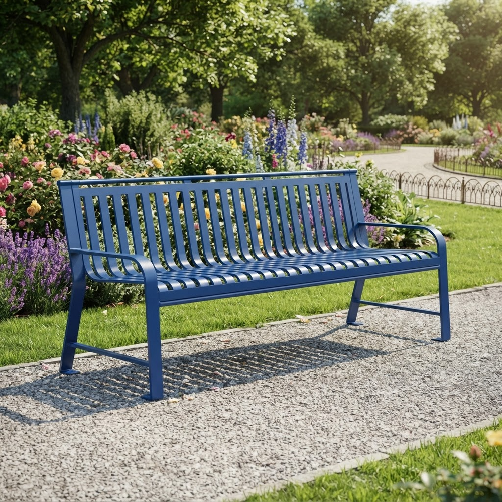 A blue metal park bench with a slatted back and seat, placed on a gravel path in a lush green garden with flowers and trees in the background.