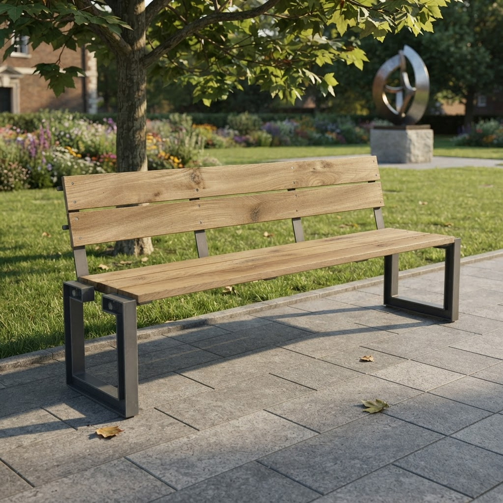 A modern outdoor park bench with a light brown wooden seat and backrest slats supported by a dark gray metal frame, situated on a paved pathway in a landscaped garden.