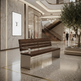 A modern wooden and stainless steel outdoor-style bench placed in a luxury shopping mall atrium with marble walls, a staircase, and a potted tree in the background.