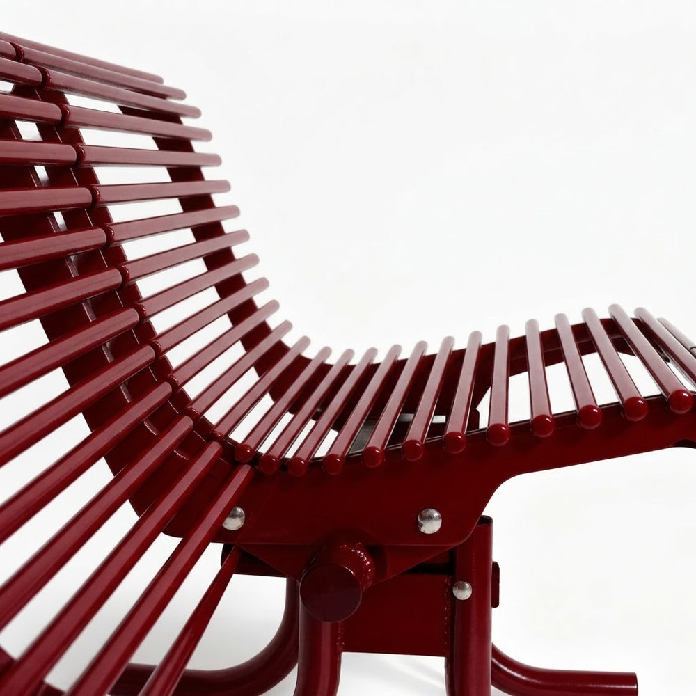 A close-up studio shot of a modern lounge chair with a curved back and seat made of parallel reddish-brown slats, set against a plain white background.