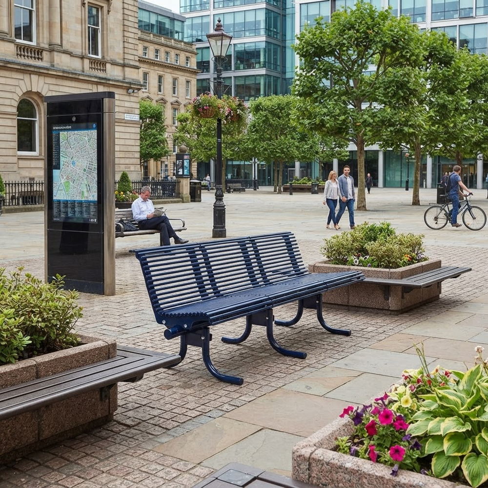 A dark blue slatted outdoor park bench in a city plaza, shown in a real urban environment with trees, pedestrians, a map kiosk, and stone paving.