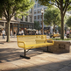 A bright yellow metal mesh park bench with black legs in a sunny urban plaza, surrounded by trees, pedestrians, and city buildings.