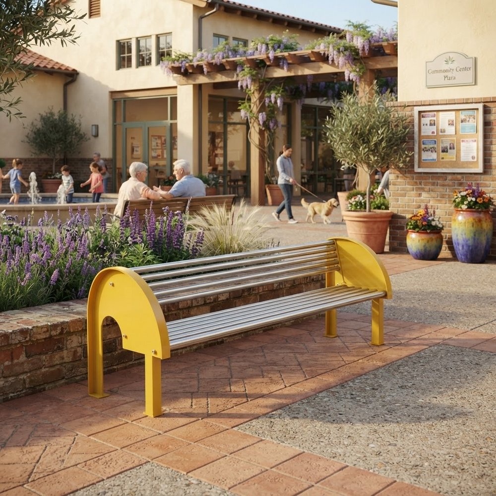 A modern outdoor bench with a bright yellow curved frame and silver metal slatted seat, placed on a paved plaza in front of a building with people sitting nearby.