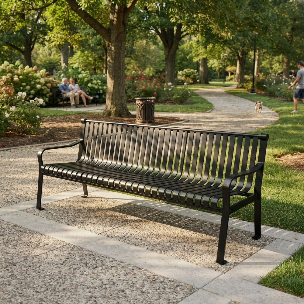 A black metal park bench with a slatted back and seat, placed on a stone path in a sunny, tree-lined park. In the background, people are sitting on a bench and a dog is walking near a trash can.