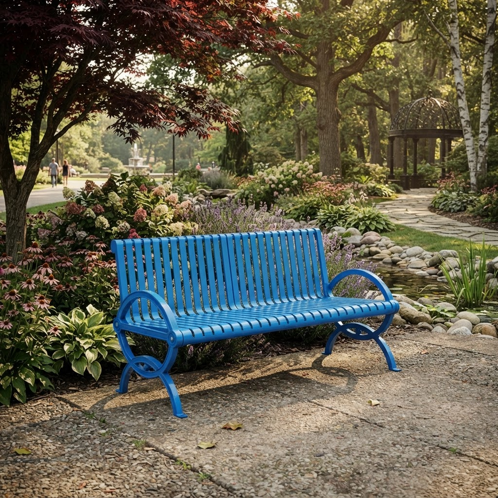A bright blue slatted metal garden bench placed outdoors on a stone path beside a landscaped garden with trees, flowers, and a small pond.