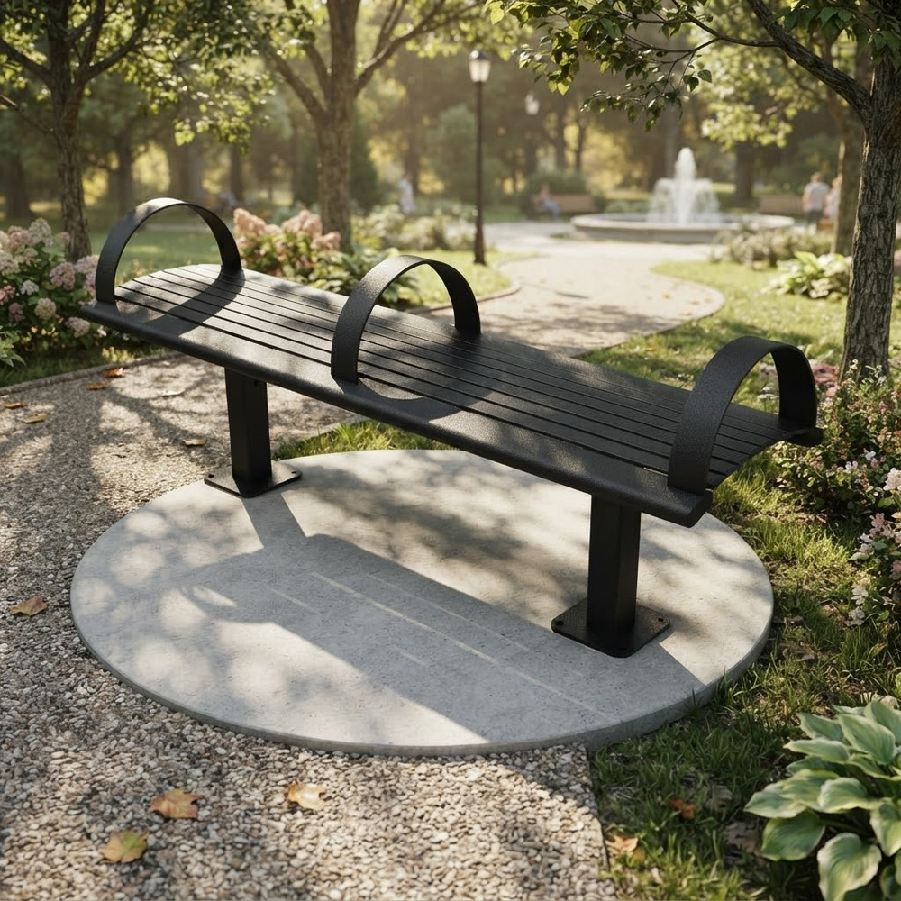 A modern black metal park bench with curved armrests, mounted on a round concrete base in a landscaped garden with trees, gravel paths, and a fountain in the background.
