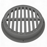 A gray round manhole cover made of cast iron, with a grid-like pattern and the text 'CAMP NO-DRINK' inscribed on the surface.