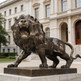 Roaring lion artwork cast in bronze, featuring a flowing mane and strong anatomical detail