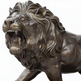 Powerful bronze lion sculpture in mid‑roar, highlighting muscular definition and dramatic energy.