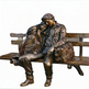 Bronze sculpture of two people sitting on a bench