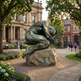Bronze human sculpture with tightly folded limbs and a dynamic compressed posture