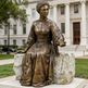Sitting Catherine McAuley sculpture featuring a long gown and extended hand gesture