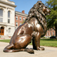 Sculpted bronze lion in a dignified seated pose, featuring a flowing mane and solid form