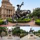 Dynamic bronze statue of a cowboy atop a rearing horse, capturing motion and rodeo energy.