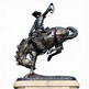 Bronze cowboy and horse statue in an energetic bucking pose with realistic anatomical detail.