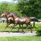 Pair of bronze running horse sculptures with raised front legs and realistic anatomical detail