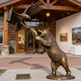 Bronze statue of a bear and an eagle in front of a building with artwork on the wall.