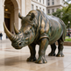 Bronze rhinoceros statue in front of a building
Detailed metal rhinoceros artwork with sculpted skin patterns and strong horn structure
