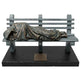Statue of a person lying on a bench with a blanket, on a white background
Bronze Homeless Jesus sculpture lying on a bench with draped blanket