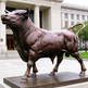 Bronze bull statue in front of a classical building