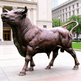 Bronze bull statue in front of a classical building