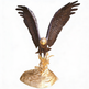 Bronze eagle sculpture with wide outstretched wings standing on a golden rocky base