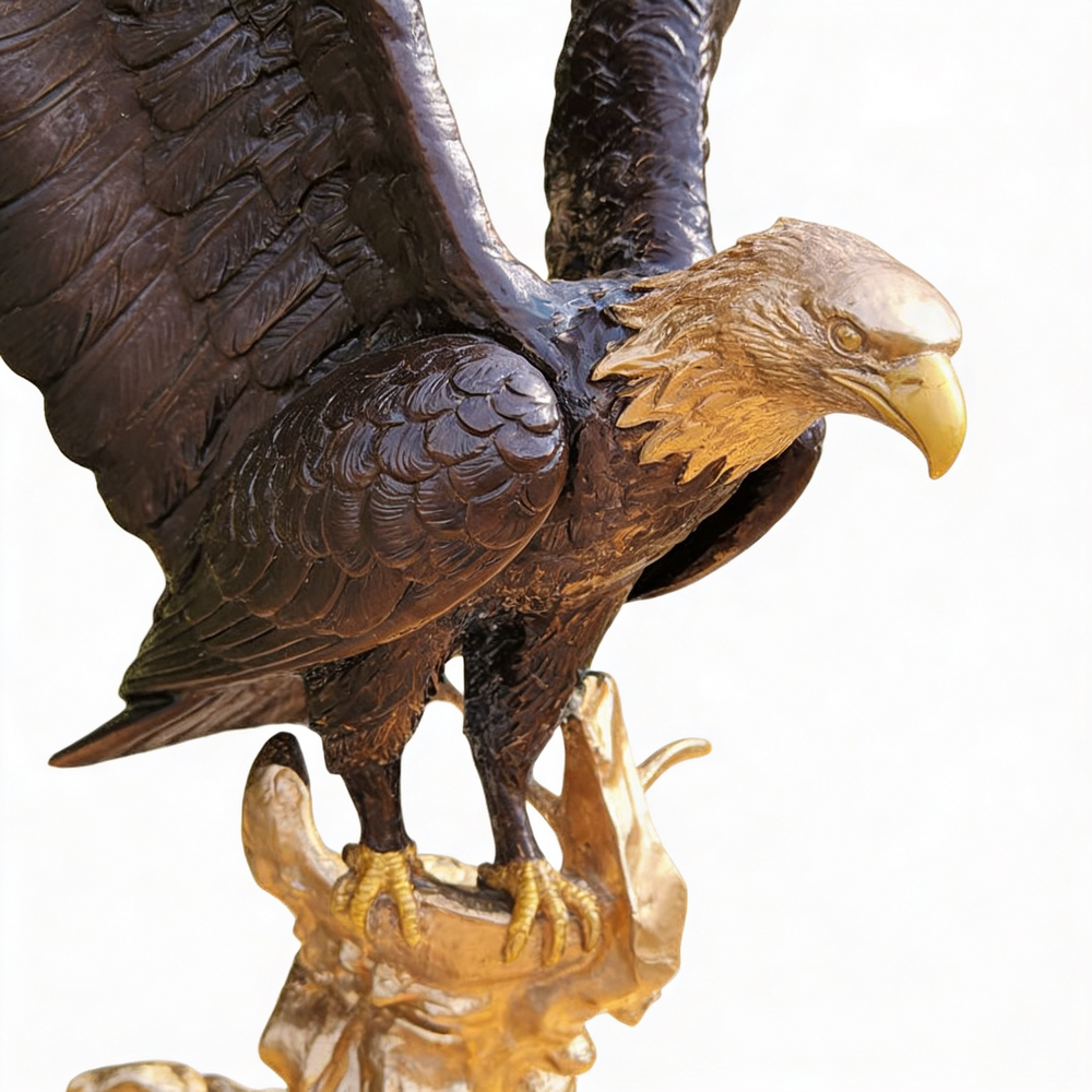 Decorative bronze eagle with open wings, perched on a stylized golden rocky surface