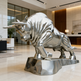 Metallic bull statue in a modern indoor setting
Polished steel bull sculpture with lowered head and pointed horns