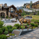 Bronze moose statue in front of a luxurious house with mountains in the background