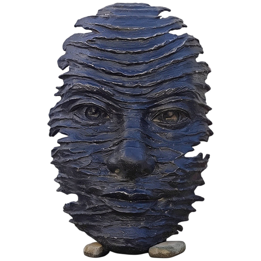 Blue stone sculpture of a face on a white background
