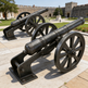 Two historical cannons on wheels in front of a castle-like building.
Realistic metal cannon sculpture for outdoor installation