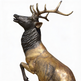 Naturalistic bronze stag sculpture with strong antlers and lifelike body proportions.