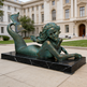Bronze mermaid statue in front of a large building