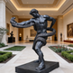 Statue of a muscular figure with a snake in an elegant indoor setting