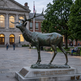 Bronze statue of an elk with expressive posture, textured fur, and detailed antler structure