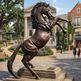 Dynamic bronze horse statue captured mid‑rear, showcasing strength and expressive movement