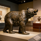 Bronze bear statue in a museum setting
