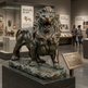 Bronze lion sculpture in a museum setting with visitors and exhibits.