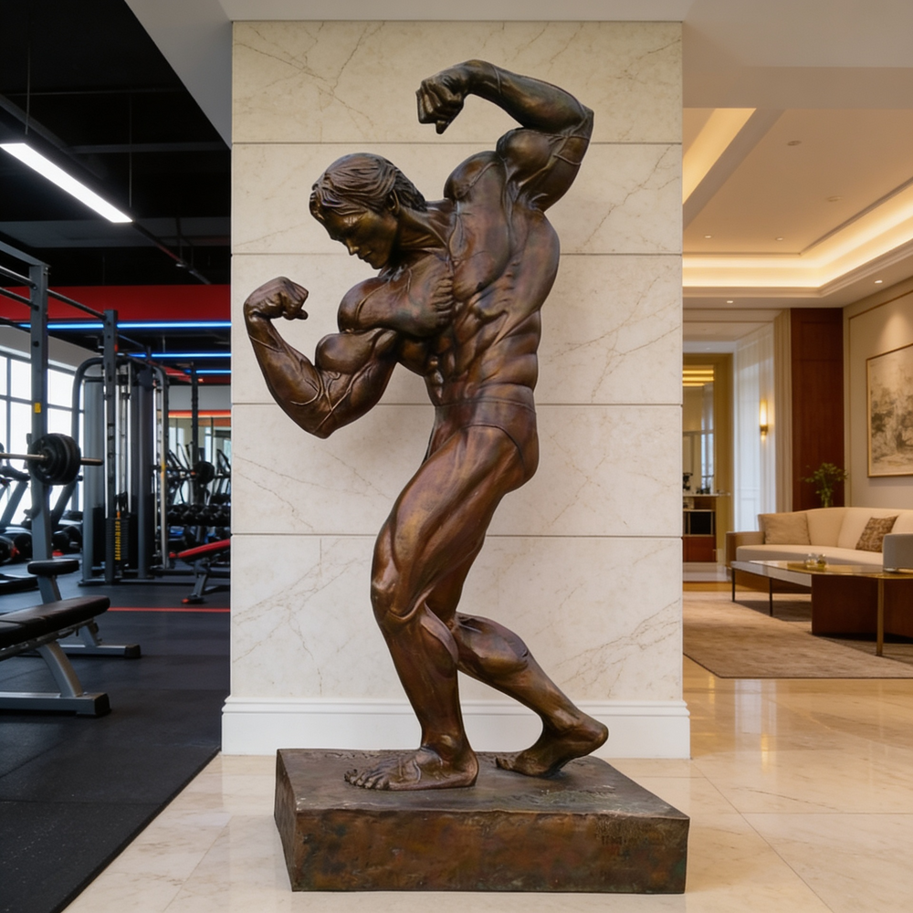 Bronze statue of a muscular figure in a gym setting