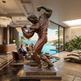 Bronze statue of a muscular figure in a luxurious indoor setting with a pool and ocean view.