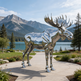 Reflective moose sculpture in a park with mountains and lake in the background