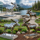 Statues of moose in a scenic outdoor setting with mountains and water.