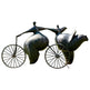 Bronze abstract sculpture of two stylized human figures riding bicycles, featuring rounded forms and dynamic motion